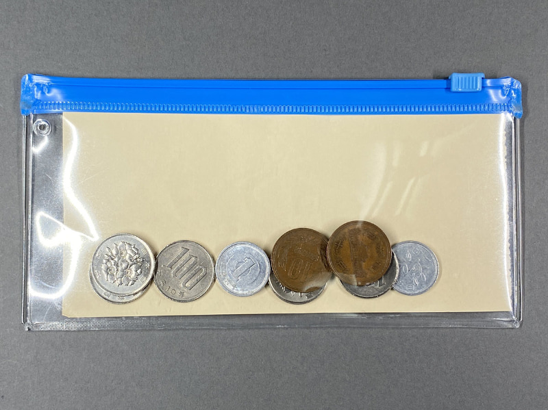 1万円札と同じサイズに切った紙を入れ……なんで本物の1万円札じゃないのか、って？　本物の1万円札など紙幣の画像ってPhotoshopで編集できなくて面倒なんスよ〜。さておき、1万円札サイズの紙を入れてみたら、イイ感じでフィット。右はサイフに適するサイズにシーラーとカッターでコンパクトに改造したもの。ちなみにこのケース、6.5インチiPhoneも入る。入れるのにコツが要るが、素材が厚手なので安心感をもってiPhoneを入れておける