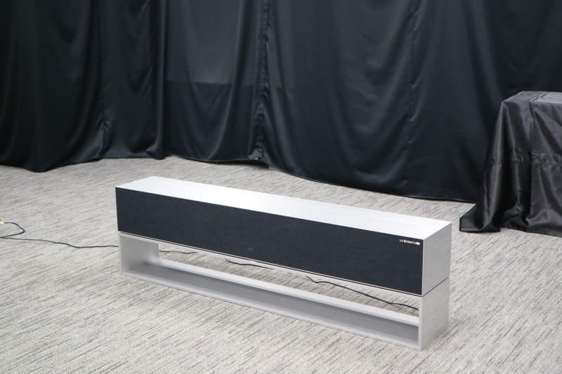 巻き取れる有機ELテレビ「LG SIGNATURE OLED R(モデルRX)」。リモコン操作でテレビが台からせり上がってくる。完全受注生産で価格は日本円で約900万円