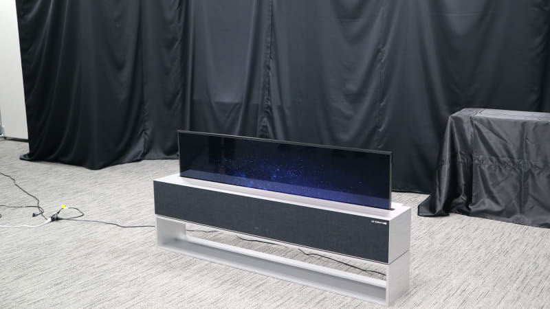 巻き取れる有機ELテレビ「LG SIGNATURE OLED R(モデルRX)」。リモコン操作でテレビが台からせり上がってくる。完全受注生産で価格は日本円で約900万円