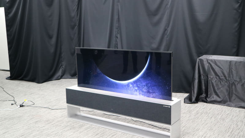 巻き取れる有機ELテレビ「LG SIGNATURE OLED R(モデルRX)」。リモコン操作でテレビが台からせり上がってくる。完全受注生産で価格は日本円で約900万円