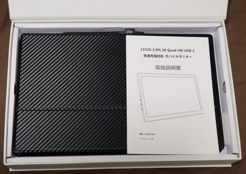 箱を開けて緩衝材を取ったら説明書とカバーに挟まれた本体が見えた。