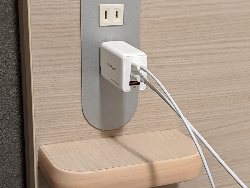 ビジネスホテルの枕元にあるコンセントに取り付け、ベッド脇で2台のスマホを急速充電するという使い方にはぴったりだ