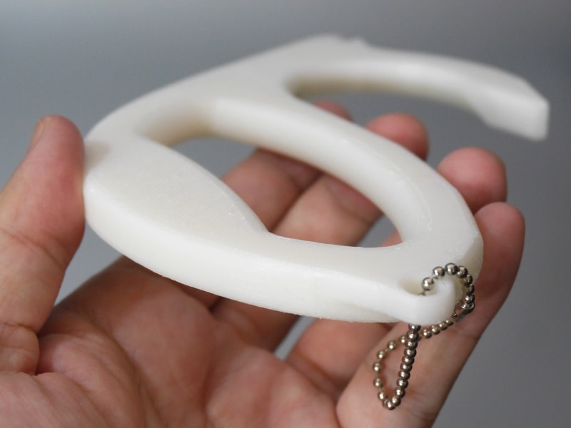 厚みは1cmを余裕で超える。後部にはボールチェーンが付属する