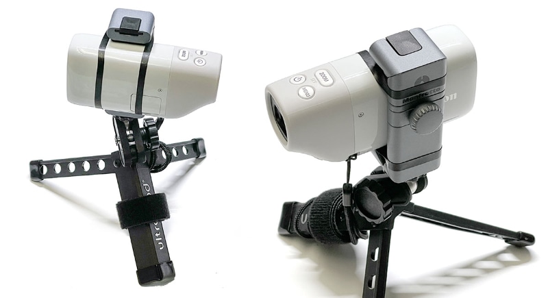 PowerShot ZOOMを三脚に固定したい場合、スマートフォンホルダーなどを利用するのが手軽だ。写真はスマートフォンホルダーにPowerShot ZOOMを挟みつつ、ゴム（モビロンバンド）で固定した様子