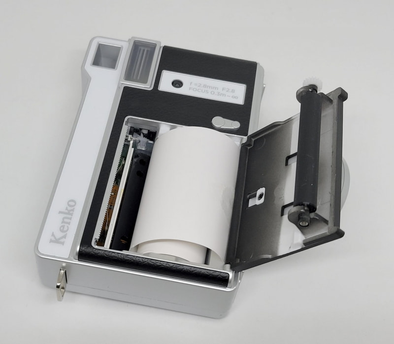 フィルム代わりの感熱ロールペーパーは正面から入れてなんちゃってレンズを覆うように排出される