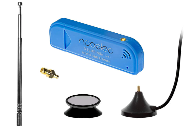 Amazonで売られていたアンテナなどが付属するNooelec「NESDR Mini 2」。左がロッドアンテナで、右下のアンテナ台座（マグネット付き)にねじ込んで使う。このアンテナ台座から伸びるケーブル先端にはMCXプラグがありSDRドングルに直接接続できる。下中央は吸盤付きの台座で、アンテナ台座（マグネット付き)を安定的に吸着できる。中央上がSDRドングル本体。その手前の金色のものはSMA→MCX変換プラグで、外部アンテナからの信号をSDRドングルに送るために使える。