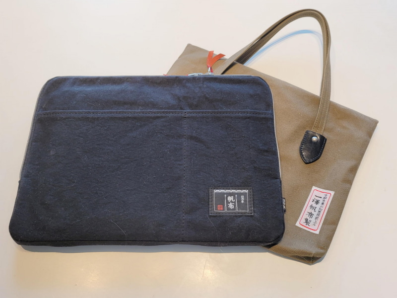 今回購入したブリーフケース。後ろは持ち手付のパソコンブリーフケースとして1年ほど使っている京都のメーカー製のもの