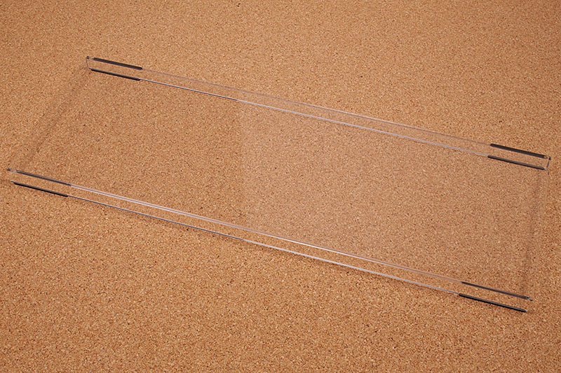 透明のアクリルでできた<a href="https://k-tai.watch.impress.co.jp/docs/column/stapa/725603.html">キーボードルー</a>。キーボードのハードカバーですな。キーボードにホコリが付着しにくくなる他、同居生物がキーボードを枕にしたことによるMacのスリープ復帰も防ぐことができる。キーボード不使用時にキーボード上を一時的な作業スペースにすることもできる。