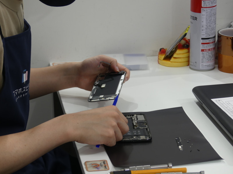 受け付けると、店舗奥で早速修理開始。20項目もの動作確認をしてから、ディスプレイを外して新しいものに交換し、筐体の縁に耐水シールを貼り付けて閉じていく。そして再び動作確認。小さい部品を扱う非常に繊細な作業だが、作業自体は15分程度でサクサクと終わった