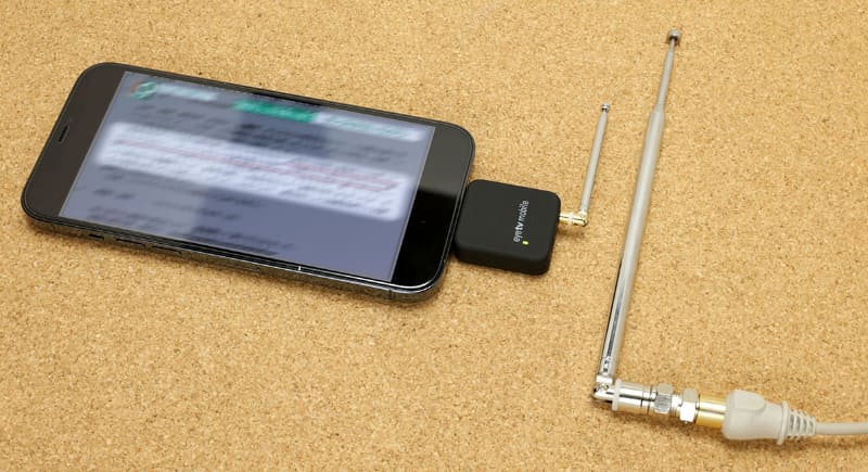 右のアンテナは、アンテナコンセントにつないだブースターの出力端子につながっている。本来はテレビやチューナーに直接つなぐが、アンテナをつなぐことで微弱ながら電波を発信する。数十cm?数m程度の距離なら、その電波をワンセグチューナー（のアンテナ）で受信できる。なお、アンテナコンセントの先につないだ（発信用）アンテナの長さは15cmくらいが良いと思う。