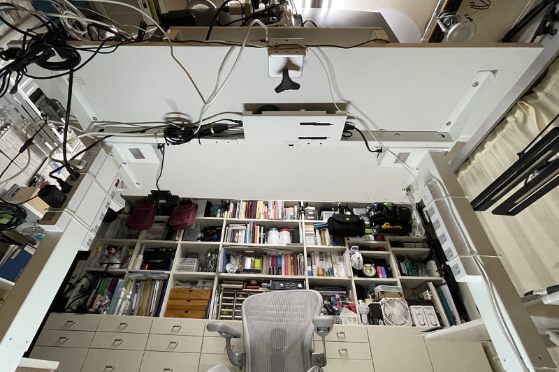 昇降デスクを下から見上げた様子。電動昇降機構は左右の脚に内蔵されている。モーターは左右の足の最上部。ACアダプターは中央にある