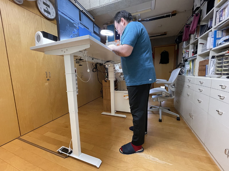 高さを120cmにした様子。立った状態で細かな作業をするために使える高さだが、立って細かな作業はほとんどしないのであった。120cmはこの昇降デスクの最も高い位置だが、この高さだとデスクをくぐって移動できたり、デスク下方を掃除しやすかったり、デスク下部の配線をラクに行えたりしてナニカと便利だ