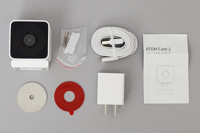 本体のほか、取り付け用のネジ類、隙間を通しやすい電源用平らなUSB Type-A to Type-Cケーブル、取扱説明書、AC電源（5V／1A）、金属プレート取付用両面テープ、金属プレートがパッケージングされている。ATOM Cam 2の足はマグネット仕様なので、玄関ドアがスチール製なら、ネジも金属プレートも不要だ