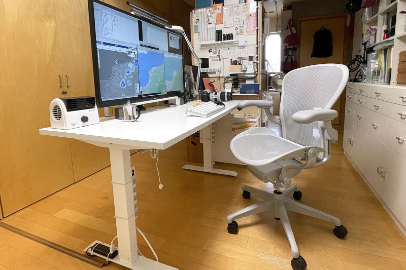 2021年9月現在の自室仕事場。<a href="https://k-tai.watch.impress.co.jp/docs/column/stapa/1341268.html" class="strong bn" target="_blank">昇降デスク</a>にデスクトップPC一式を乗せて使っている。ディスプレイは4K/約43型