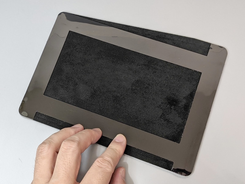 裏面には、再剥離が可能な粘着テープが貼られている（上下左右の格子になった部分）