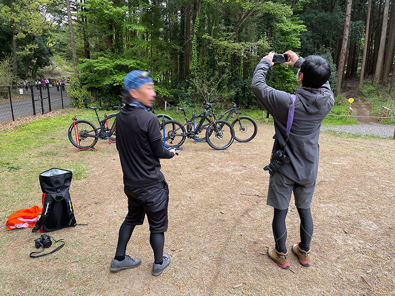 これは自転車の具体的な車体が見えてしまうとマズいという場合。ポートレートボケAIは人物が複数でもそれぞれを被写体として認識するが、この写真に適用したら良好（好都合？）な結果となった。ただ、右人物の腕の間から見える背景が被写体として自動認識されてしまった。これも手動で修正できる