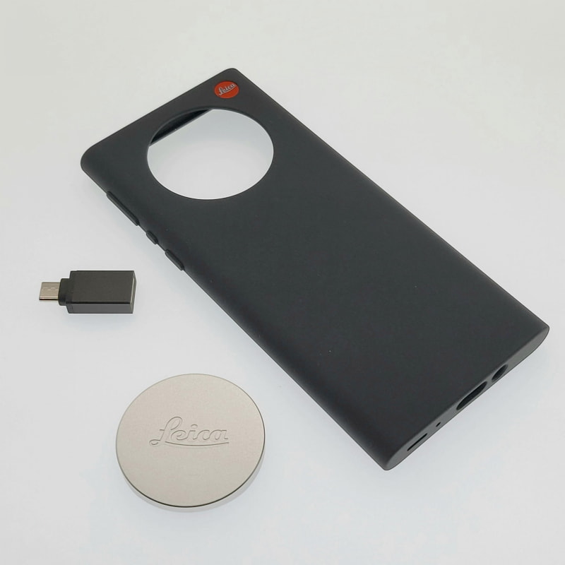 本体購入時に付属するシリコン製ケース（黒）とシルバーのレンズキャップ