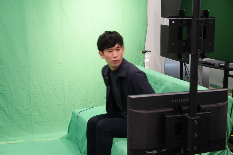 相手も同様のソファ、背景合成のためグリーンバックになっている