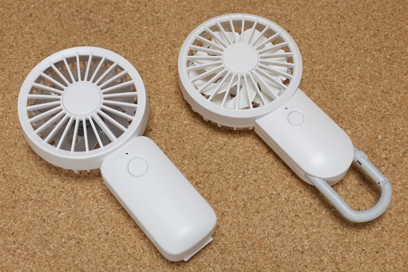 リズム製ポータブル扇風機2機種。左が「Silky Wind Handy Fan S」（1980円）で手に持っても自立させても使える。右が「Silky Wind Mobile 2」（2780円）で、バッグなどに引っ掛けるカラビナ付きで、付属スタンドを使えば自立する。どちらも携帯サイズで、風量の豊かさが特徴的。