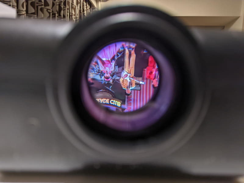 上面の鏡に反射した映像はレンズを通して前面に投射されて壁面に映るはず