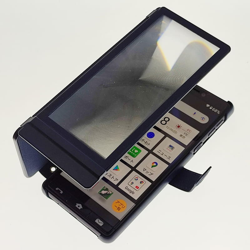 実際に使用シーンではこんな感じ。ルーペ面とカードフォルダーのあるスタンド面は無段階の角度で固定できるので、2面のヒンジ部分を指先で支えてこういう感じで拡大できる