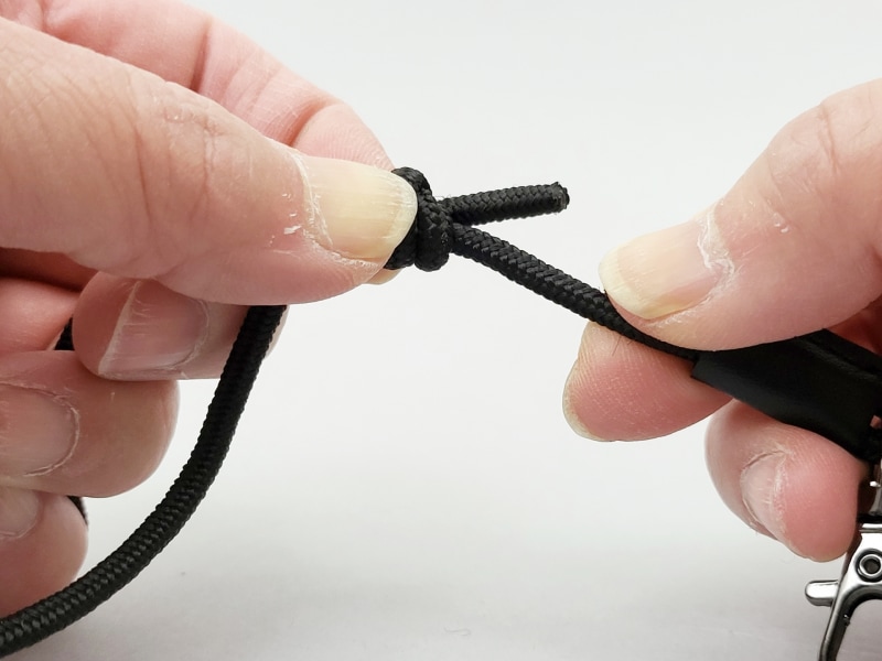 痛くなりにくいように、肩にかかる部分は二重になっています。結び目のカバーをずらしてから、このように結び目を指で押さえ、他方のコードを引っ張れば長さ調節ができます。なお、指を離した状態だと、引っ張っても、長さは変わりません