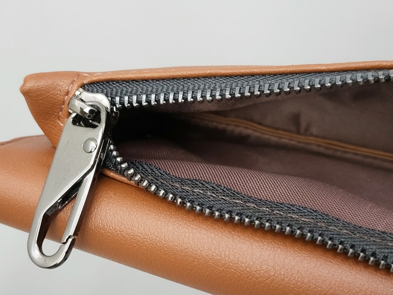 ファスナーの引き手部分とポーチの内側。ファスナーの引き手はフック型なので、チャームなどを取り付けてカスタマイズもできます。内側は布張りされているので丈夫そう