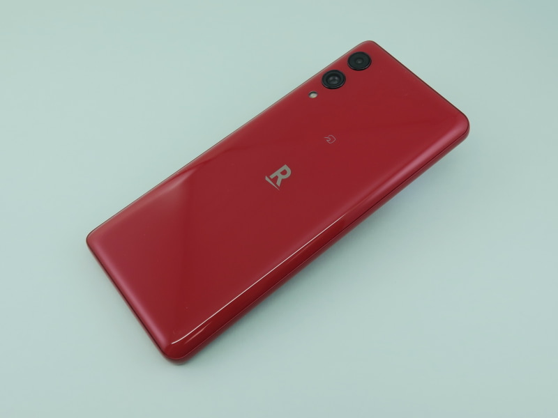 背面側はディスプレイと同じように、左右両側面のエッジ部分を湾曲させた形状を採用。中央に楽天の「R」マーク、その少し上側におサイフケータイのアイコンがプリントされている