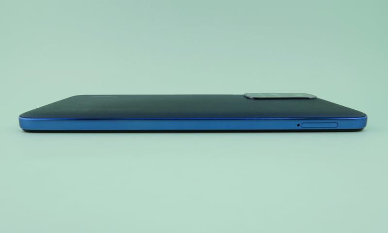 左側面にはSIMカードスロットを装備。背面はわずかに両端側が湾曲した形状。カメラ部の突起は薄い