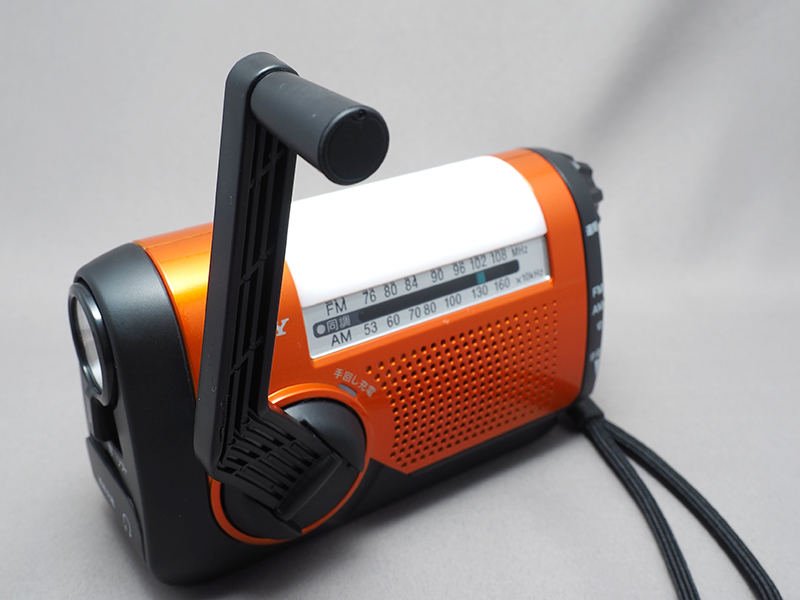 手回し充電器を内蔵する。側面には懐中電灯、上面（白い部分）にはソフトライトを備える