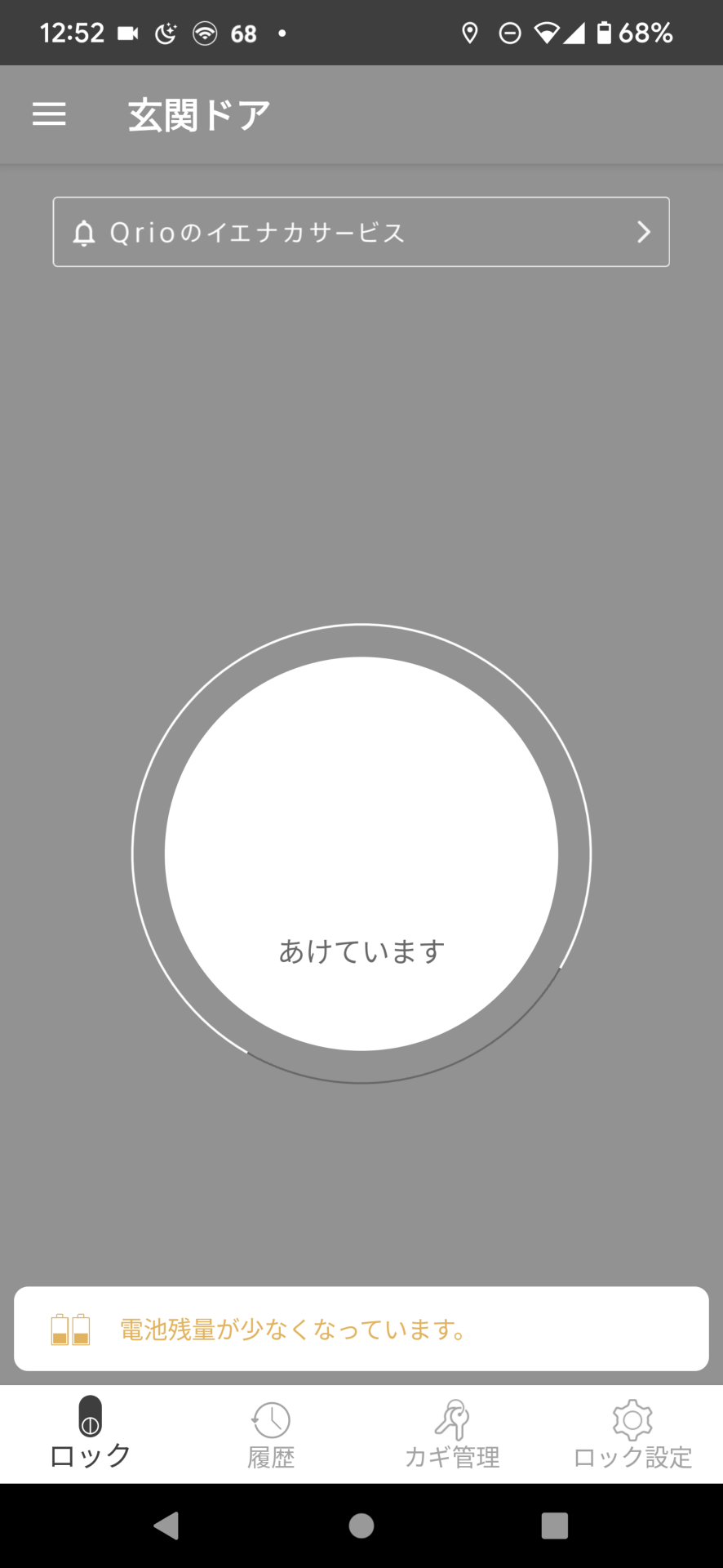 スマホでQrio Lockを解錠するには、スマホを取り出し、アプリを起動、画面上の丸いボタンをタップすると解錠操作に入る