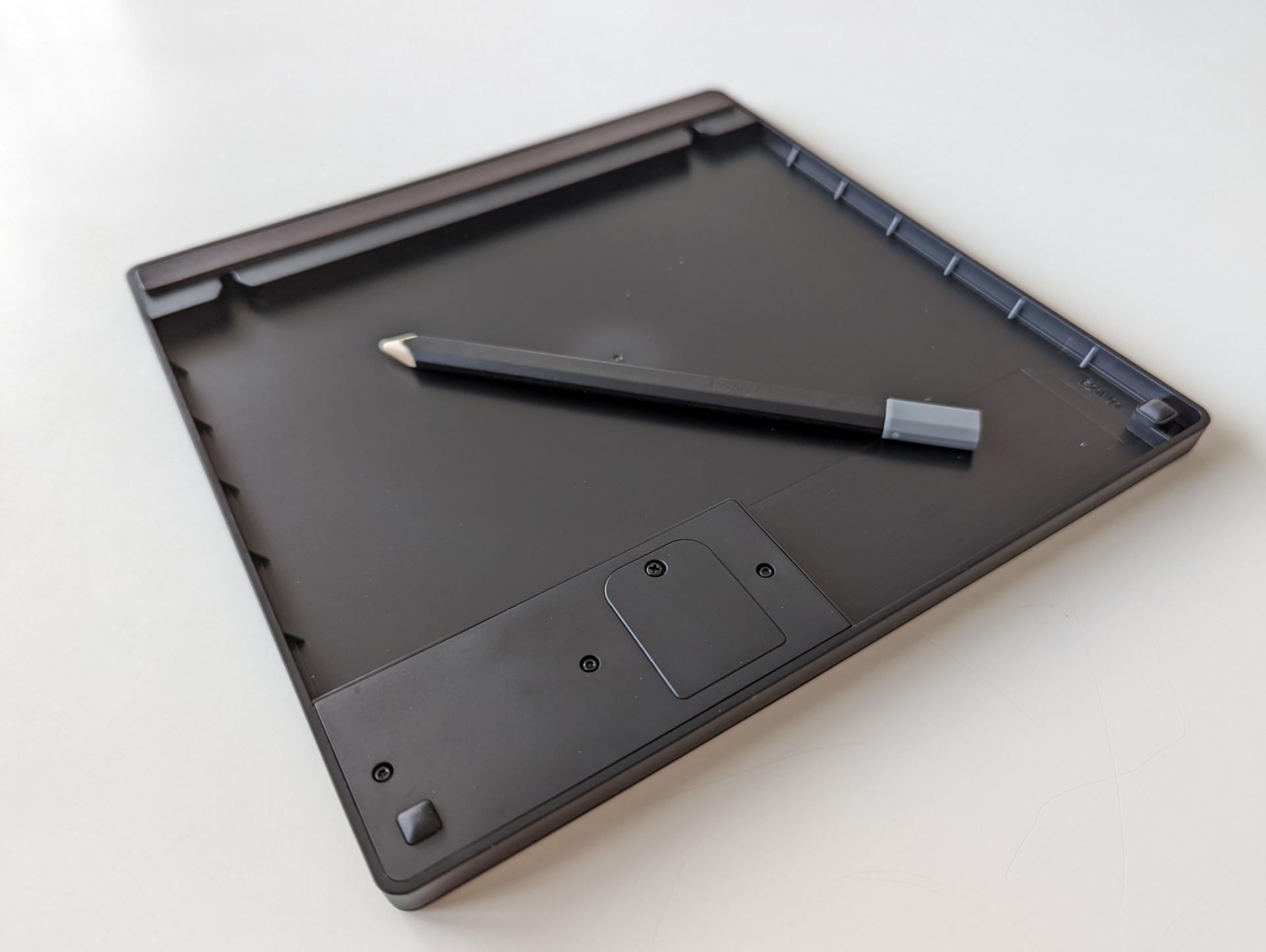 裏面にはバッテリー収納スペースと金属面に固定するマグネットとゴム脚、ネジで壁面固定するためのフックが配置されている