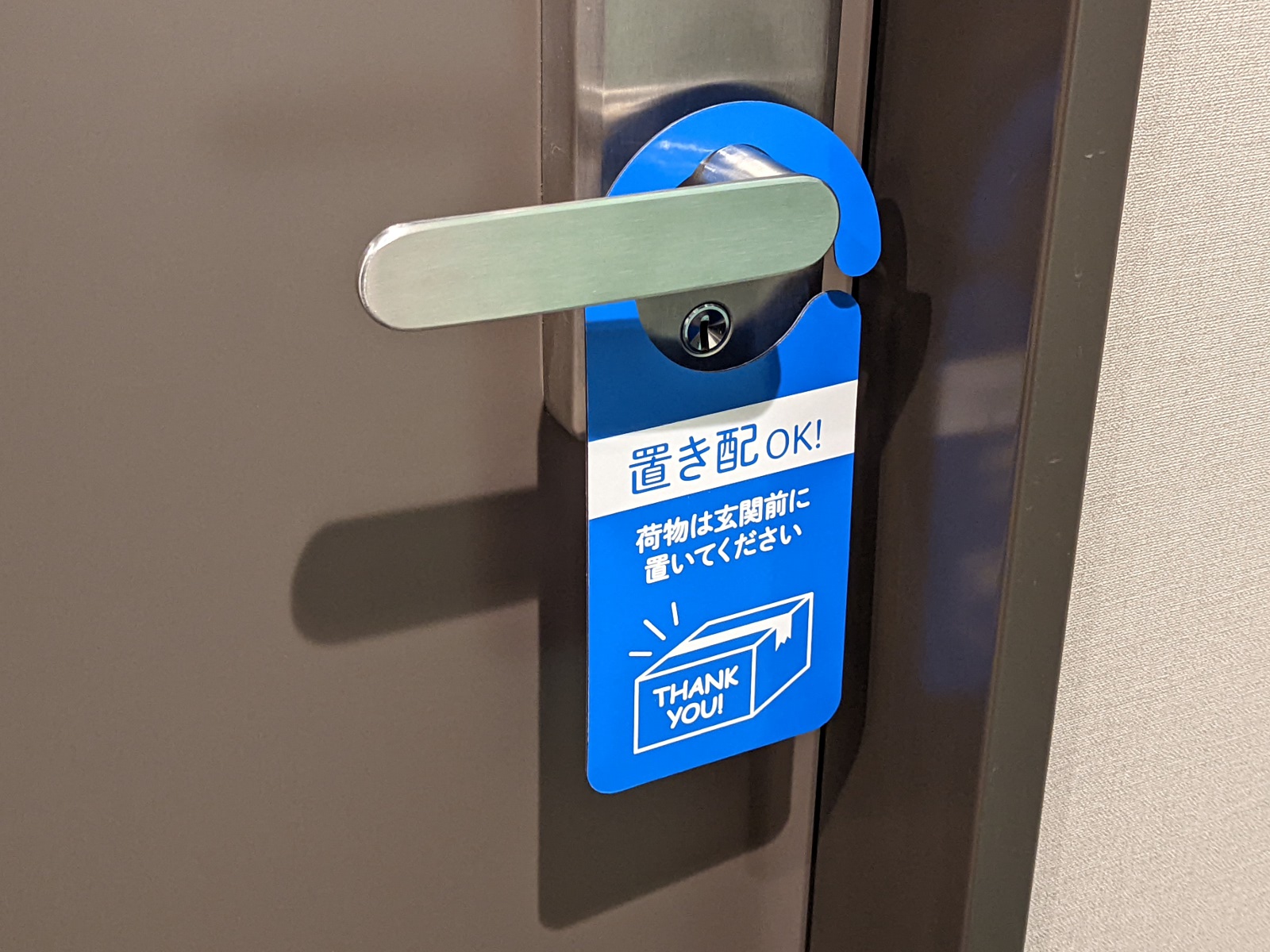 実際に扉に下げたところ。本来ならばインターホン周辺に掲示できるとよいのだが、これでも十分気づいてもらえるだろう