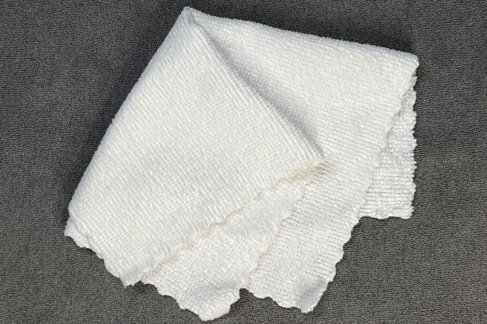 22×22cmのマイクロファイバークロスで端末を拭いている。画面もケースもフキフキ。