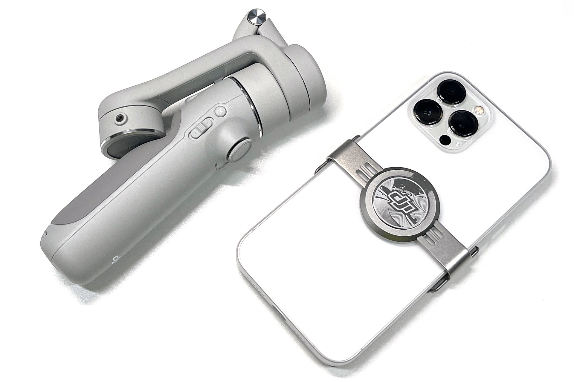 DJI OM 5とiPhone 13 Pro Max。DJI OM 5を折りたたむと携帯が容易なサイズになる。ジンバルの重さは292gで、iPhone側に取り付ける磁気スマートフォンクランプは34g。ビデオ用三脚などと比べると超軽量であり、うまく使えばビデオ用三脚のように安定感のある動画を撮れる。