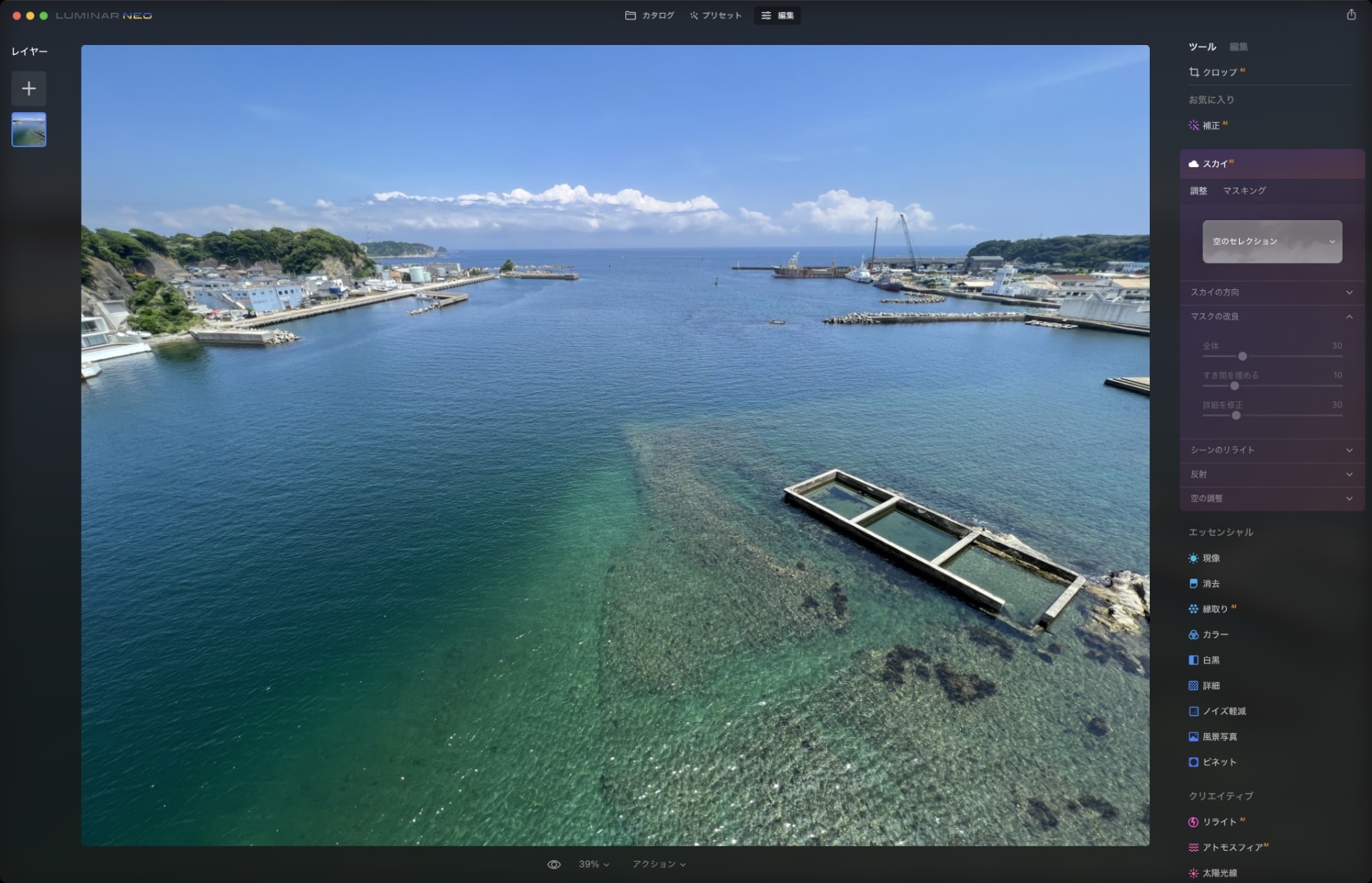 左が元画像。これを「スカイAI」で処理したのが右。夕方の空を選ぶと、その夕空が合成されるとともに、海の色も夕方っぽくなりつつ、海面には夕空の映り込みも現れる。よ～く見ると部分的に違和感がある箇所（左奥の建物手前が明るすぎるとか）を見つけられるが、でもまあだいたい「キレイな夕景ですね」と納得してしまうのではないだろうか。なお、AIによる処理から細かな手動での効果調整まで含めて、1分かからず右の画像ができた。