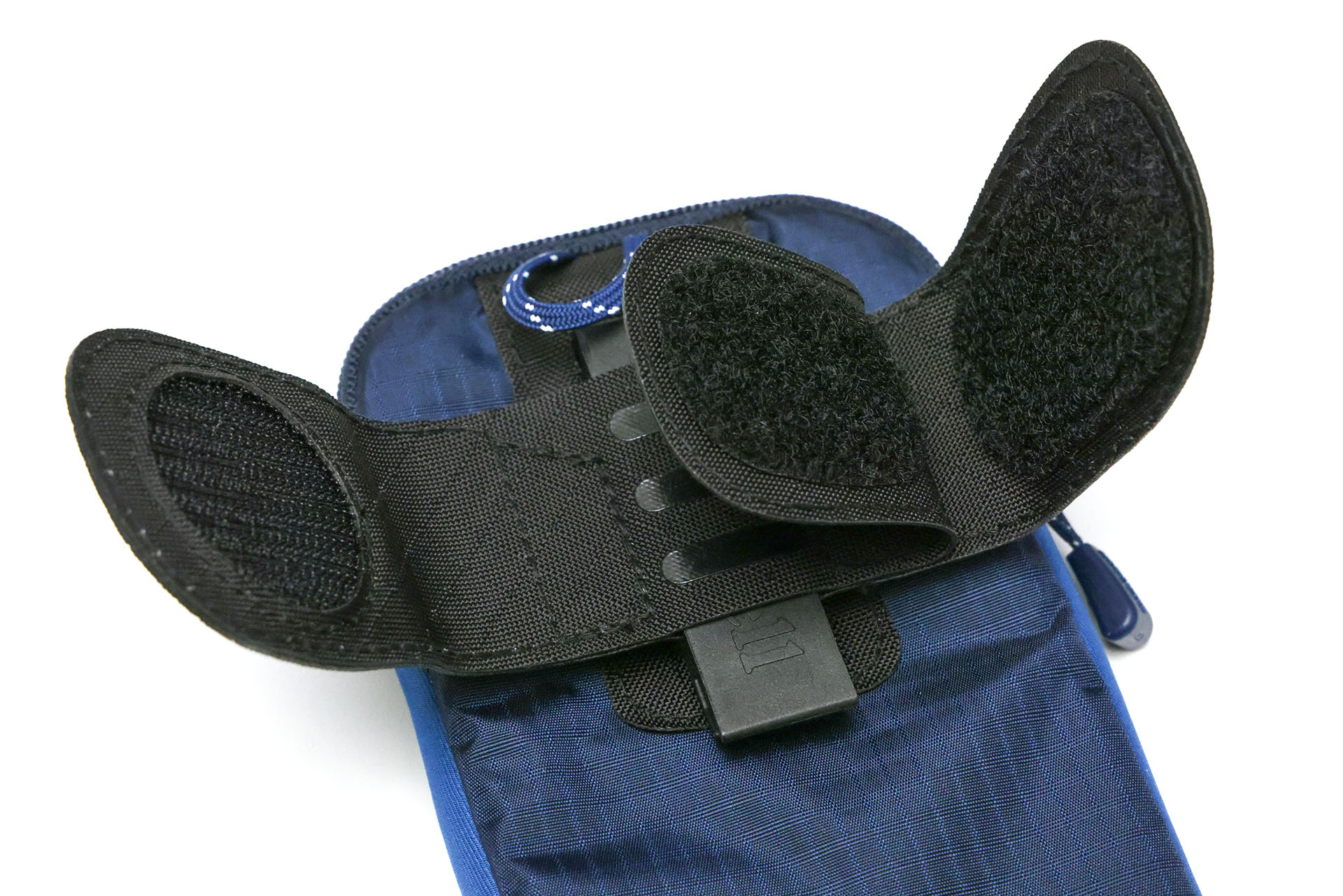 裏面の面ファスナーは3枚式で、バックパックのショルダーハーネスを1度挟んだうえに、さらにもう1枚の面ファスナーで固定できる。落下防止とズレ防止を兼ねて留めることができる。