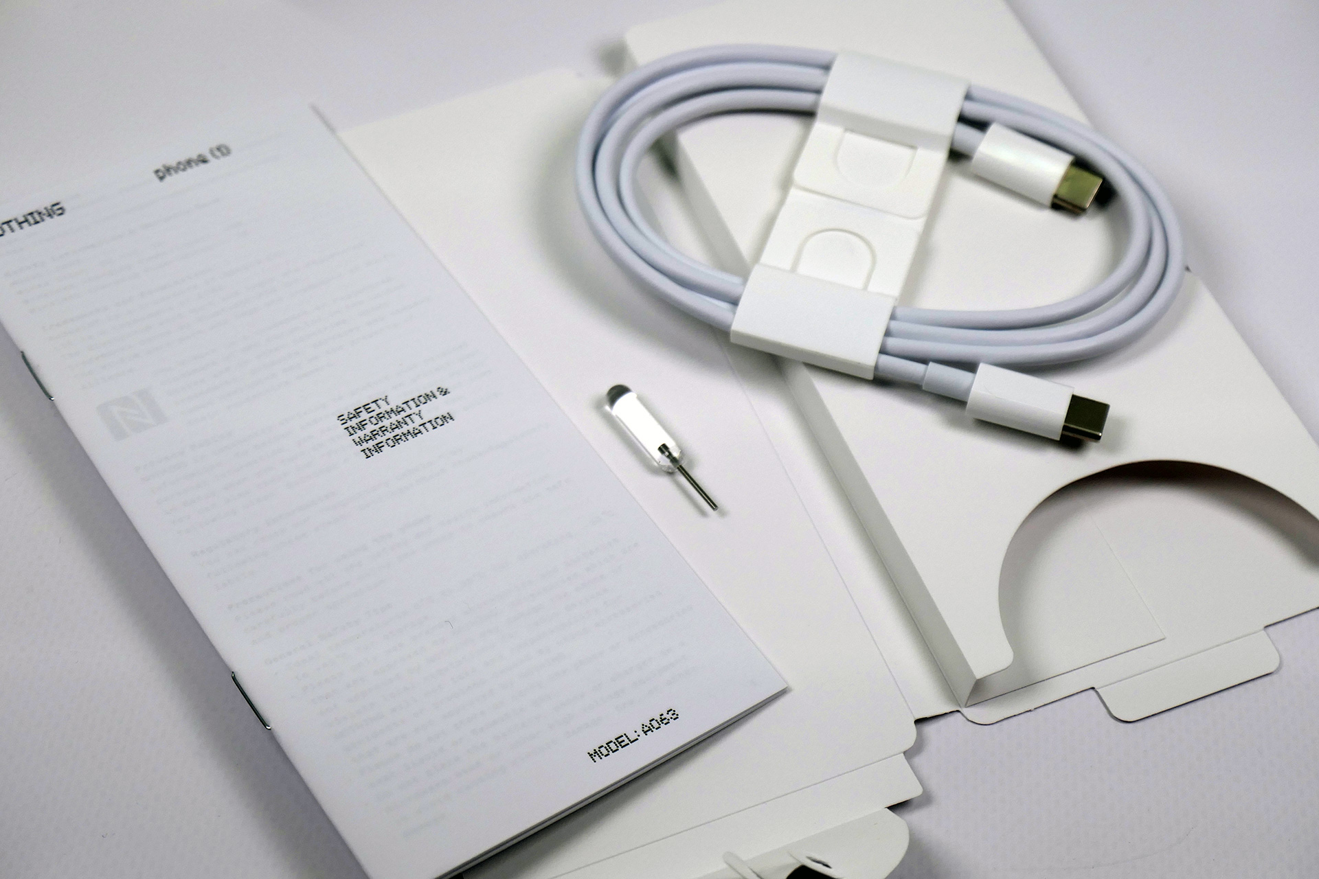 「Nothing Phone (1)」の付属品。中央はSIMピンで、SIMピンとしてはユニークな見た目をしている