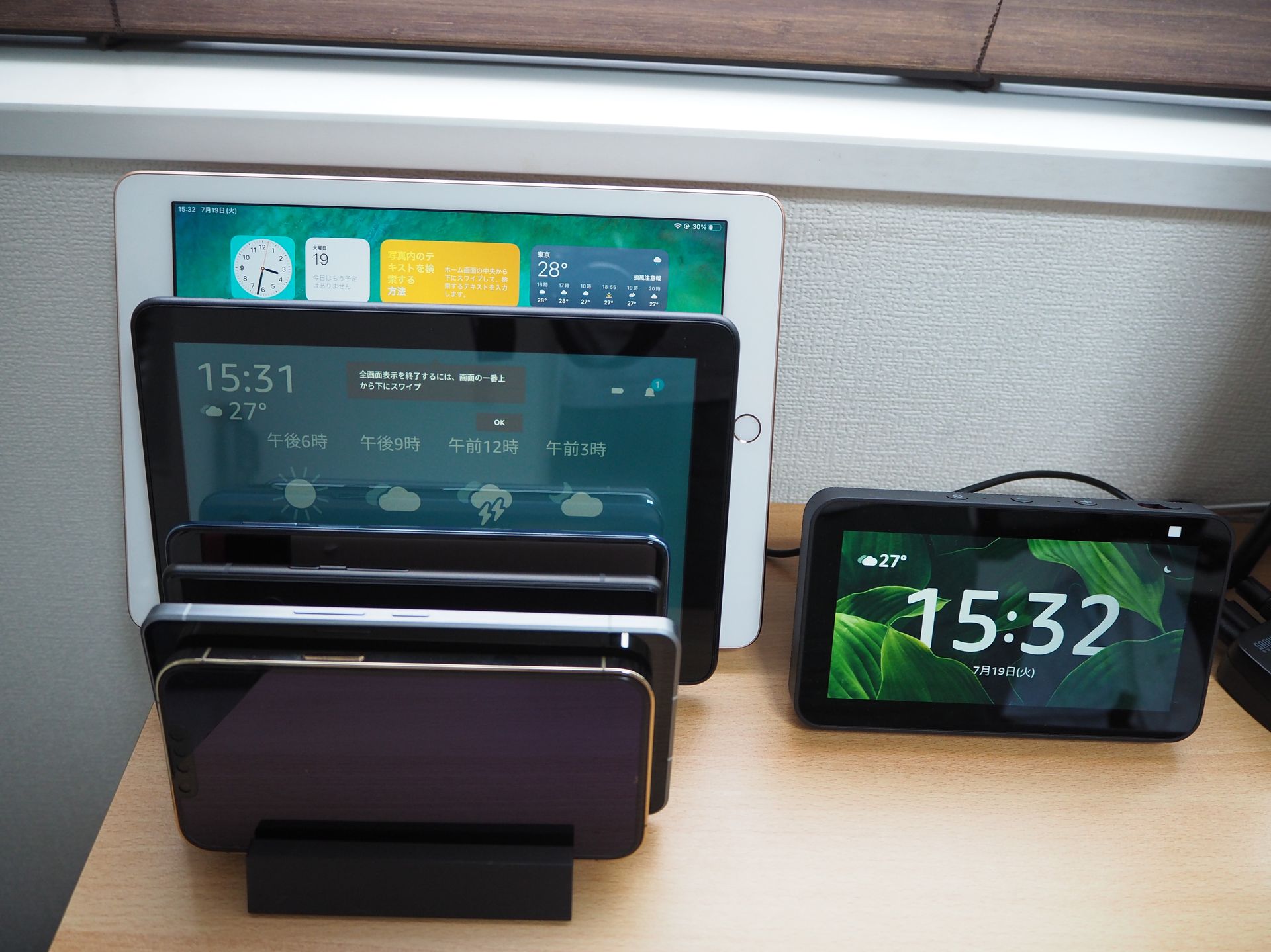 実際に複数のタブレットとスマートフォンを置いてみたところ。最初の写真と比べるとかなりスッキリした上、ブラインドも当たらない高さに収められているのが分かる
