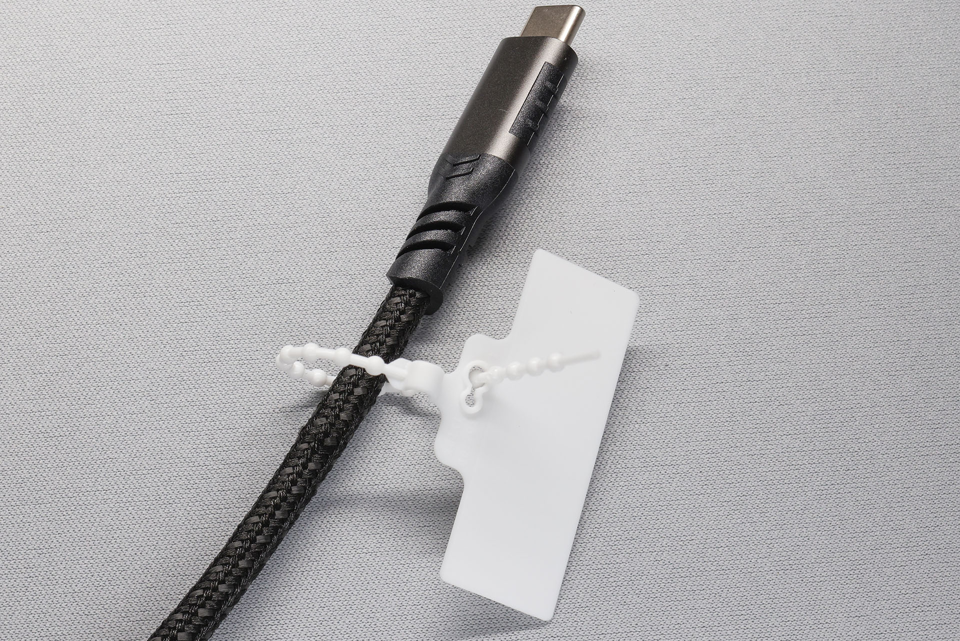 使い方は簡単で、ワイヤー部分でケーブルを巻き、ワイヤー先端をタグの穴に通す。