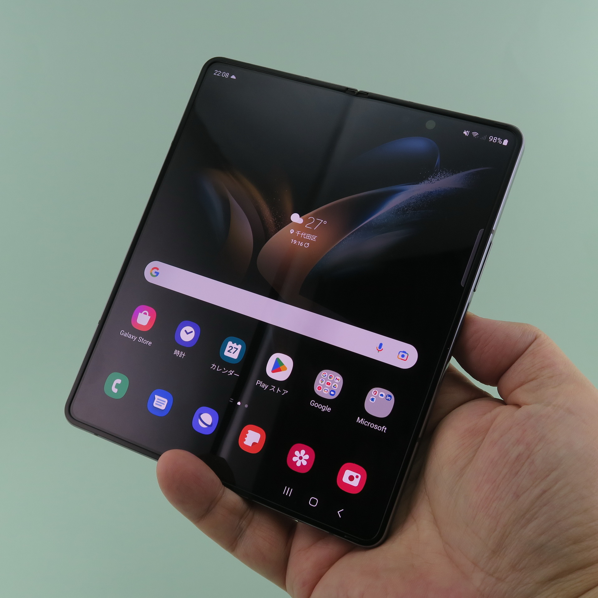 「Galaxy Z Fold4」を開いた状態で手に持ったところ。片手でも持てるが、実際に使うときは両手で挟み込むように持つと扱いやすい