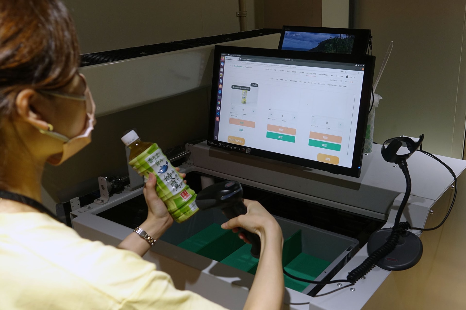 店舗裏側の補充スポット。スタッフは、商品のバーコードと賞味期限、数量を入力し補充していく。コンテナは自動移動するので、補充スポットから動かずに補充ができるので、時間短縮につながるという