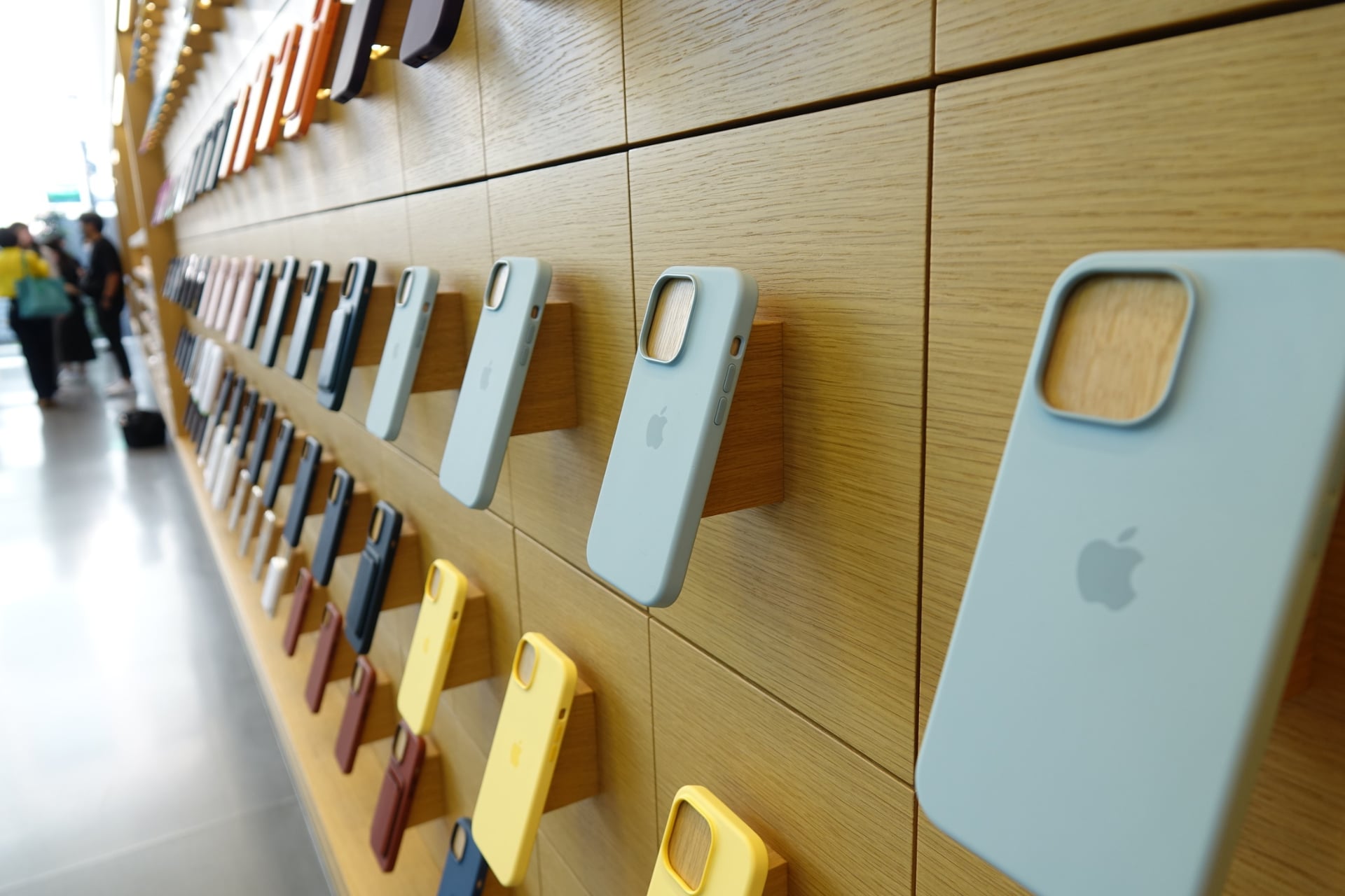 店内のディスプレイとiPhoneを手に取る来店者