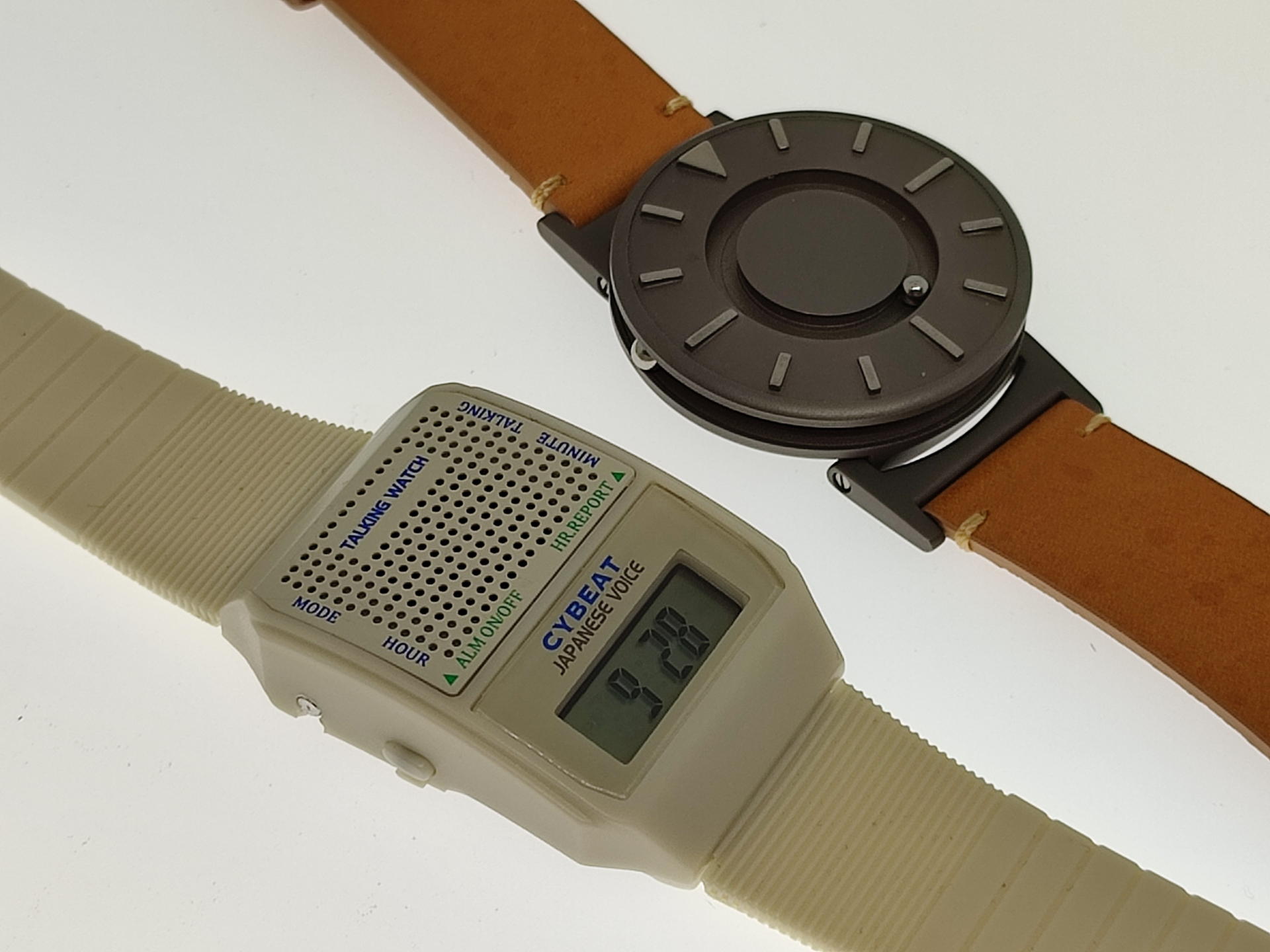 2000円くらいからあるトーキングウォッチ（左）と視覚障害者が指先で鋼球に触れて現在時刻を知るBradley（右）