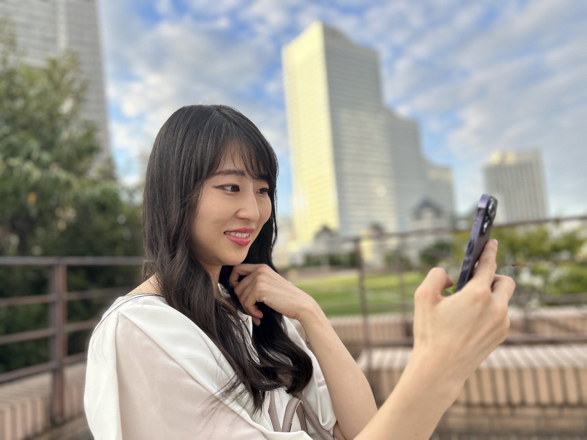 「iPhone 14」のポートレートを使い、横ワイドで撮影。背景だけでなく、手に持っている「iPhone 14 Pro」も少しボケが効いていながら、人物にはしっかりとピントが合っている