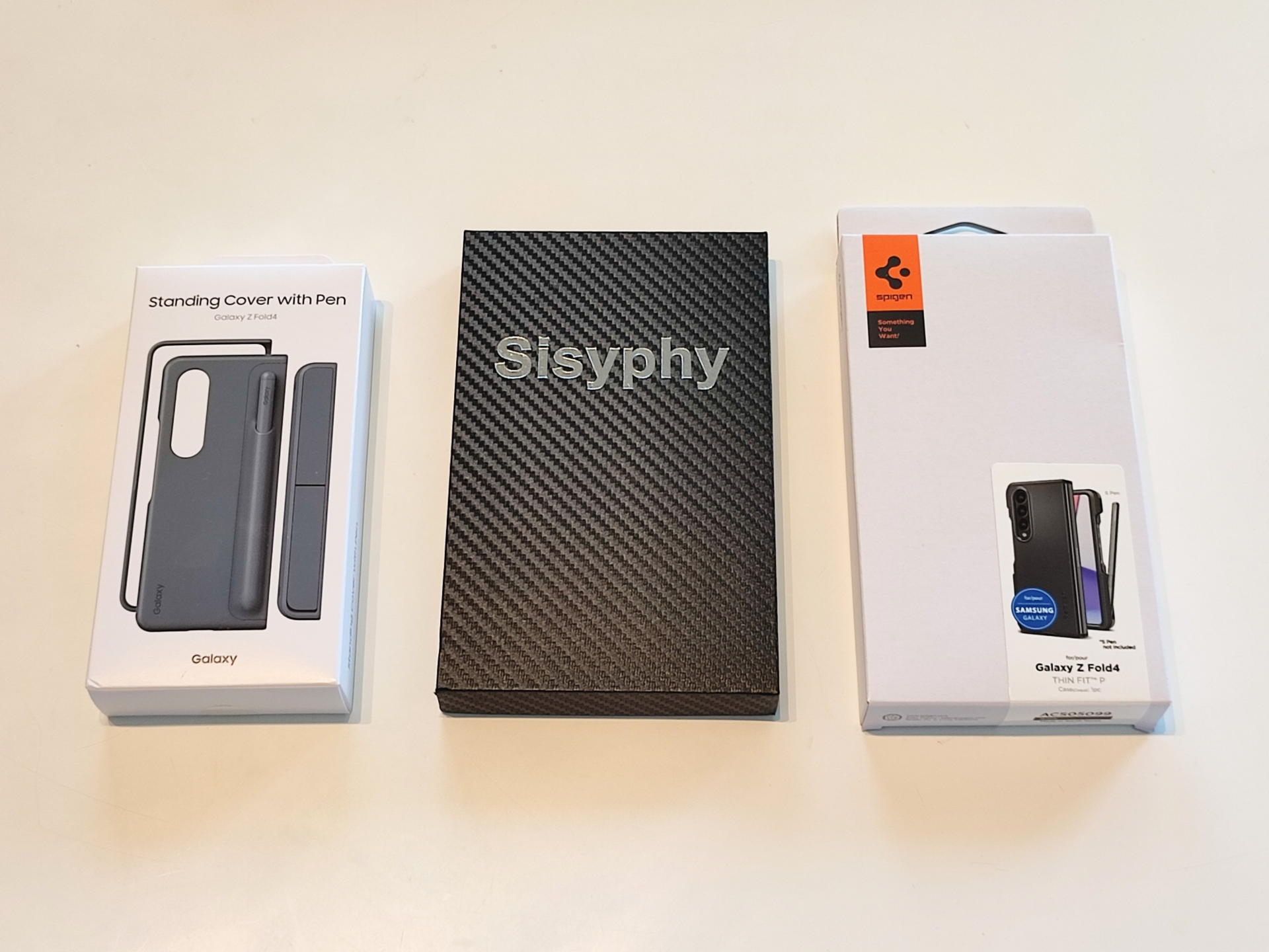 左から純正のGalaxy Z Fold4 Standing Cover with Penケース（本体より先に買った）真ん中がアラミド繊維を使った超々軽量ケース、右端はSpigenのペンホルダー付きタフケース