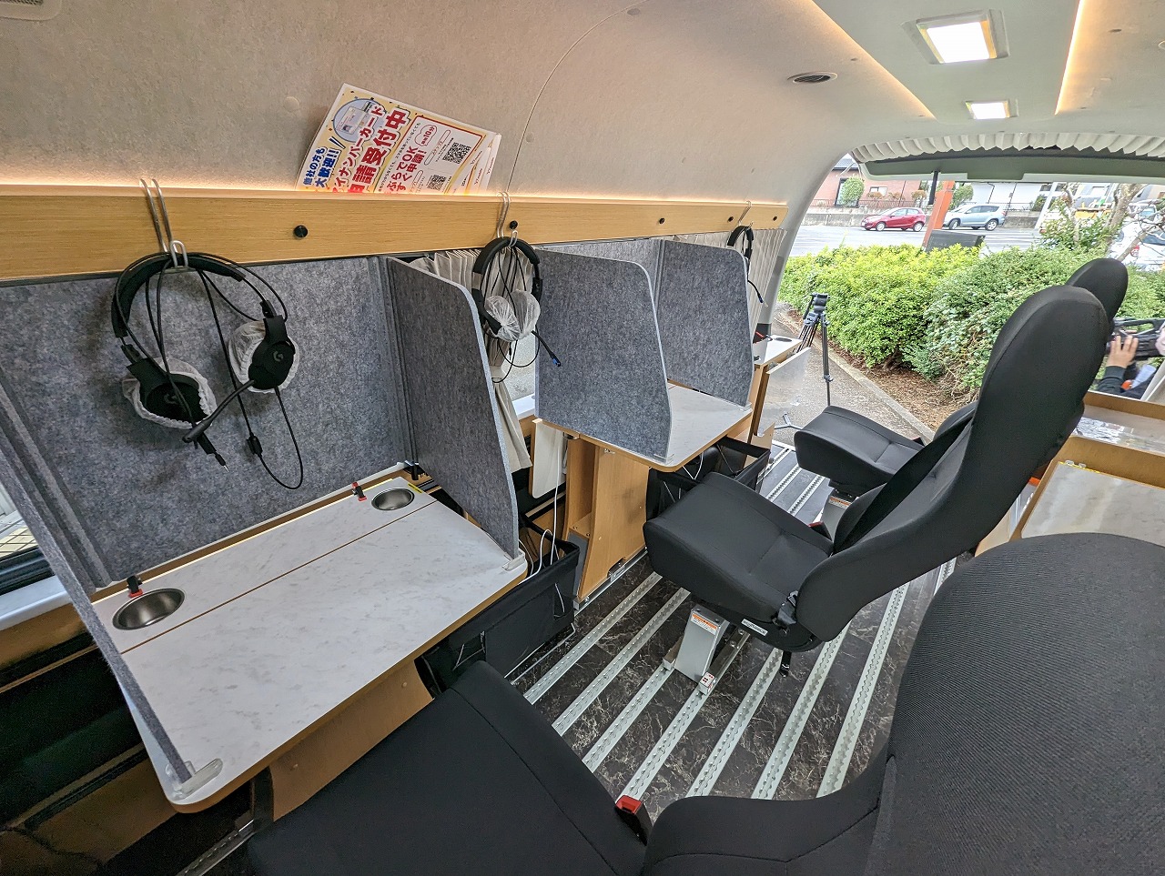 車内には3人分の机と椅子が設置されているが、マイナンバーカード申請のための車両では1席減らして、個人情報を隠すための仕切り板も設置されている