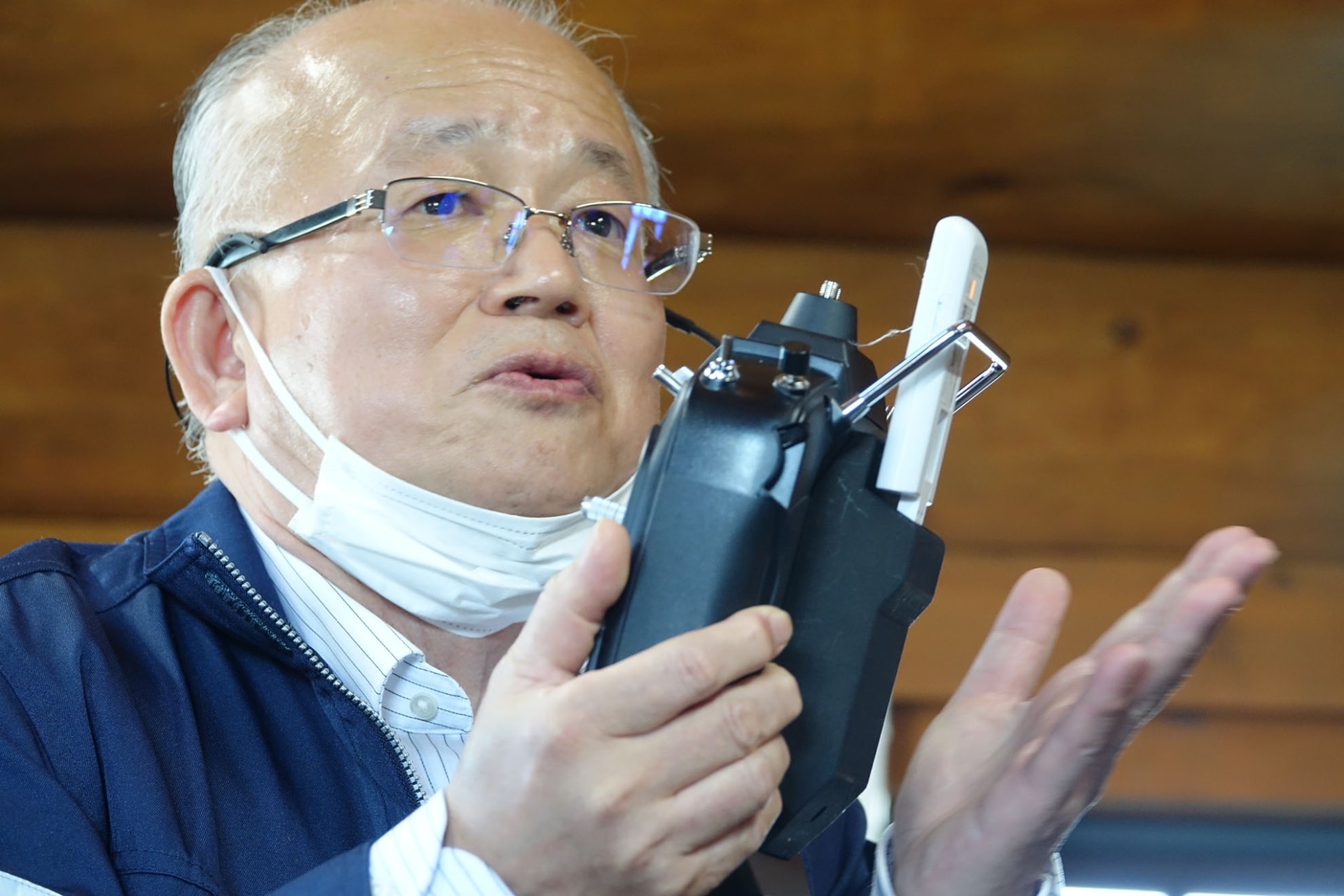 通信モジュールを備えたリモコンを手に取る藤井氏