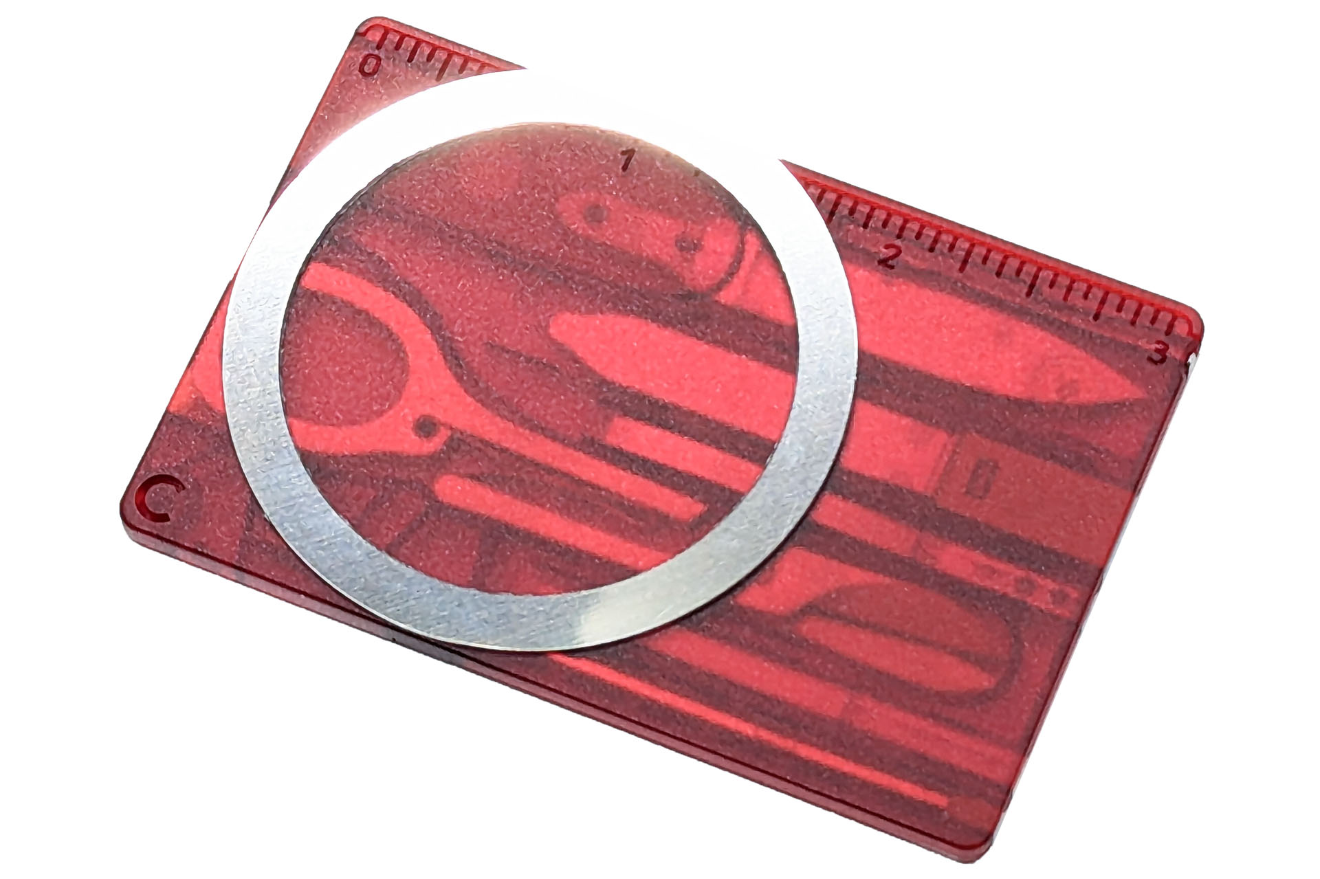 スイスカードの裏にスマートフォンケースをMagSafe化する金属リングを貼った。金属リングがほんの少しはみ出た。