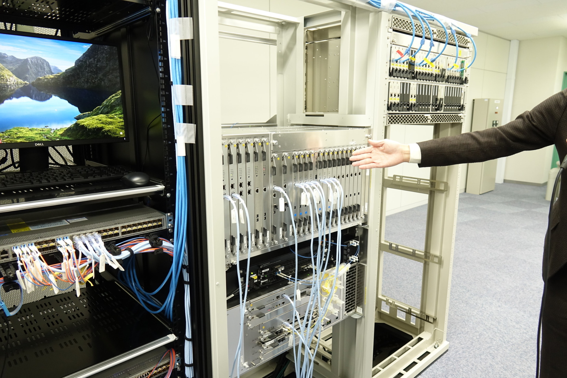 右から5G親局、4G親局などが並ぶ。検証環境で端末とコアネットワークはシミュレーターで再現する。左端に見えるのはデータの解析装置